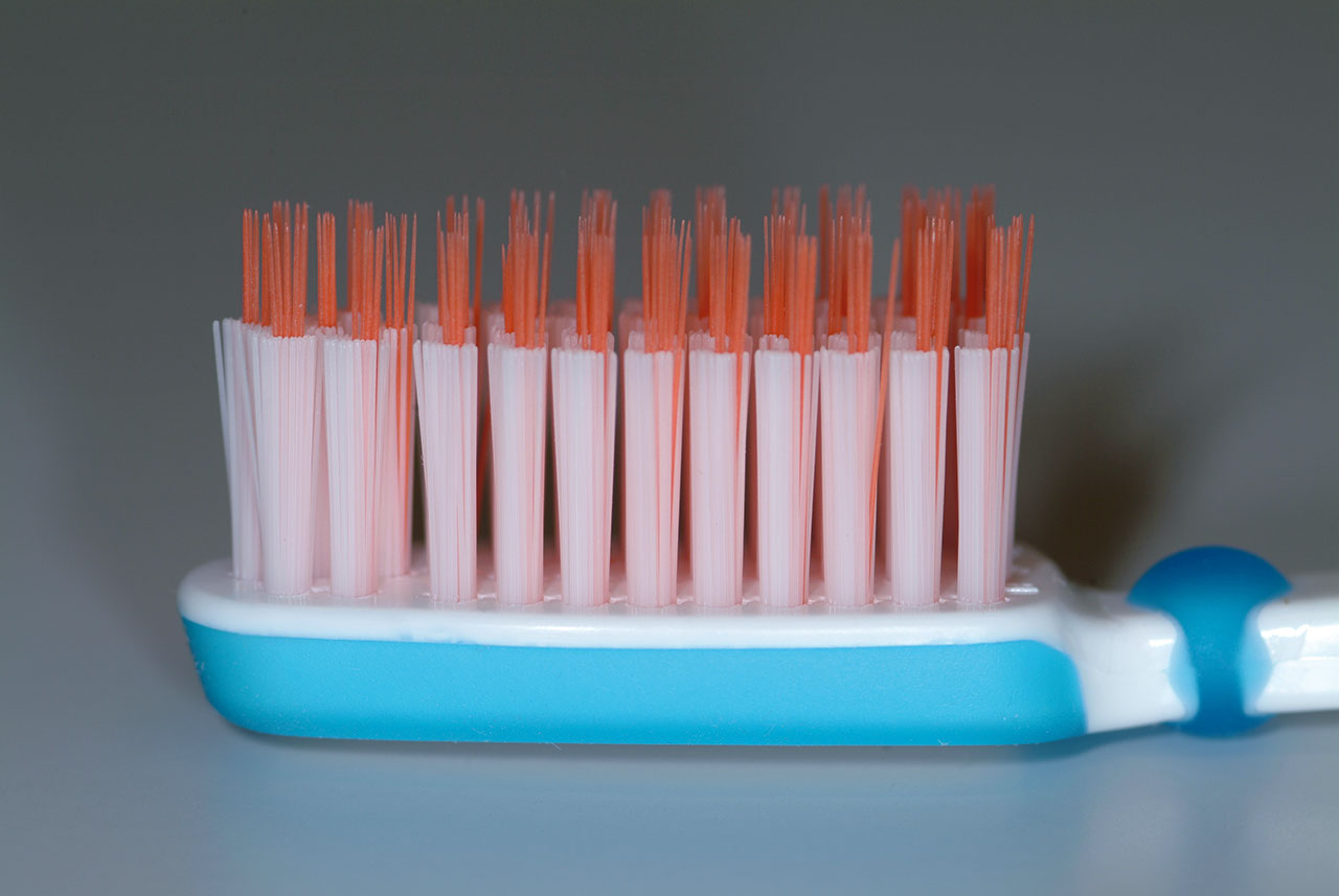 Abb. 7: Zahnbürste mit einem kompakten Borstenfeld und darüber hinausragenden dünneren Borsten – sie können Interdentalräume, Fissuren und den gingivalen Sulkus besser reinigen als eine konventionelle Bürste.