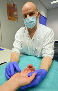 Dr. Martin Schreiber, Leitender Oberarzt der Abteilung für Plastische- und Handchirurgie des UniversitätsCentrums für Orthopädie, Unfall- und Plastische Chirurgie (OUPC) schaut auf die noch leicht gerötete Stelle des Eingriffs.
