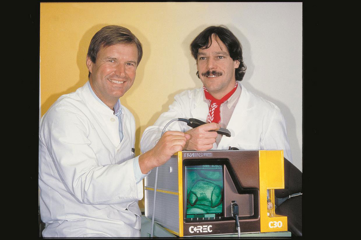 Dr. Dr. Werner H. Mörmann und Dr. Marco Brandestini präsentieren 1986 stolz einen Cerec-Prototyp. Quelle: Dentsply Sirona